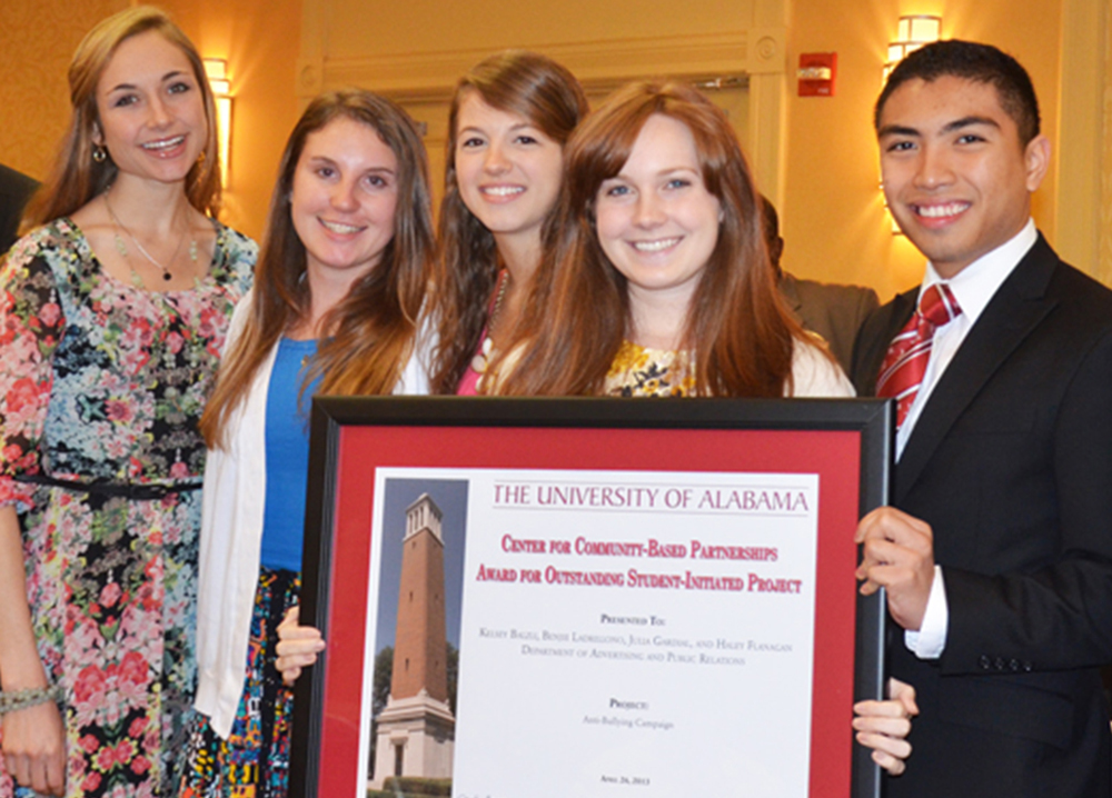 Students Kelsey Balzli, Jacquie McMahanon, Benjie Ladrillono, Julia Gardial and Haley Flanagan stand with Dr. Samory Pruitt, left, and Acting Provost Joe Benson with the certificate acknowledging their award winning ant-bullying project in the student-initiated engagment project category.