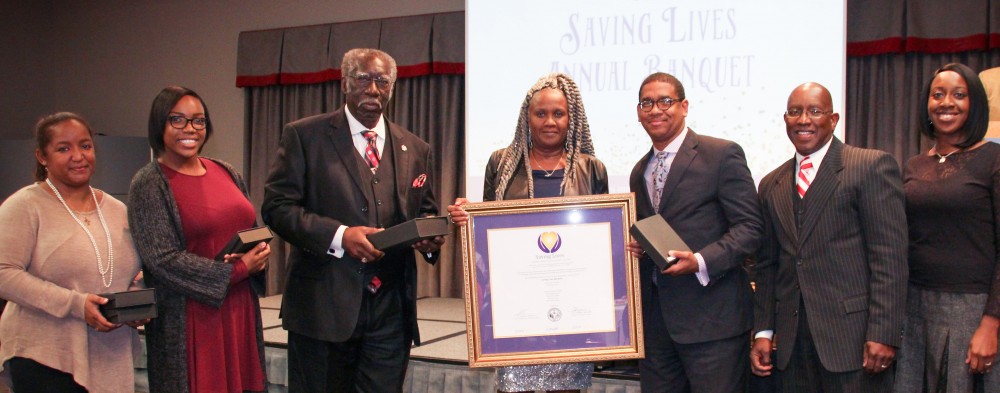 Benville Baptist Church pastor Rev. Simon Hunter (third from left) and (from left) SLI advocates Ms. Portia Jones, Ms. Ava Travis, and Ms. Annette Harris are inducted into the Saving Lives network after a year in the program. Plum Grove Baptist Church’s Rev. Antonio Gardner (third from right), and Rev. Richard L. Morgan (First African Baptist Church) join the induction as pastors of the original set of churches inducted into the network. At far right is Ms. Carol Agomo, Saving Lives program coordinator.