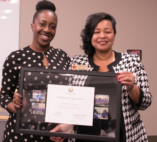 Carol Agomo receives a certificate of appreciation for her work with Saving Lives. With her is Dr. Nicole Prewitt, CCBP director of programs and partnerships for community engagement and director of the new Saving Lives Academy.