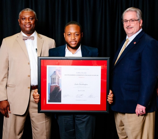 Justin Washington, MBA student, receives the Distinguished Community-Engaged Scholar Award– Student. Dr. Samory T. Pruitt is at left and Dr. John Higginbotham at right.