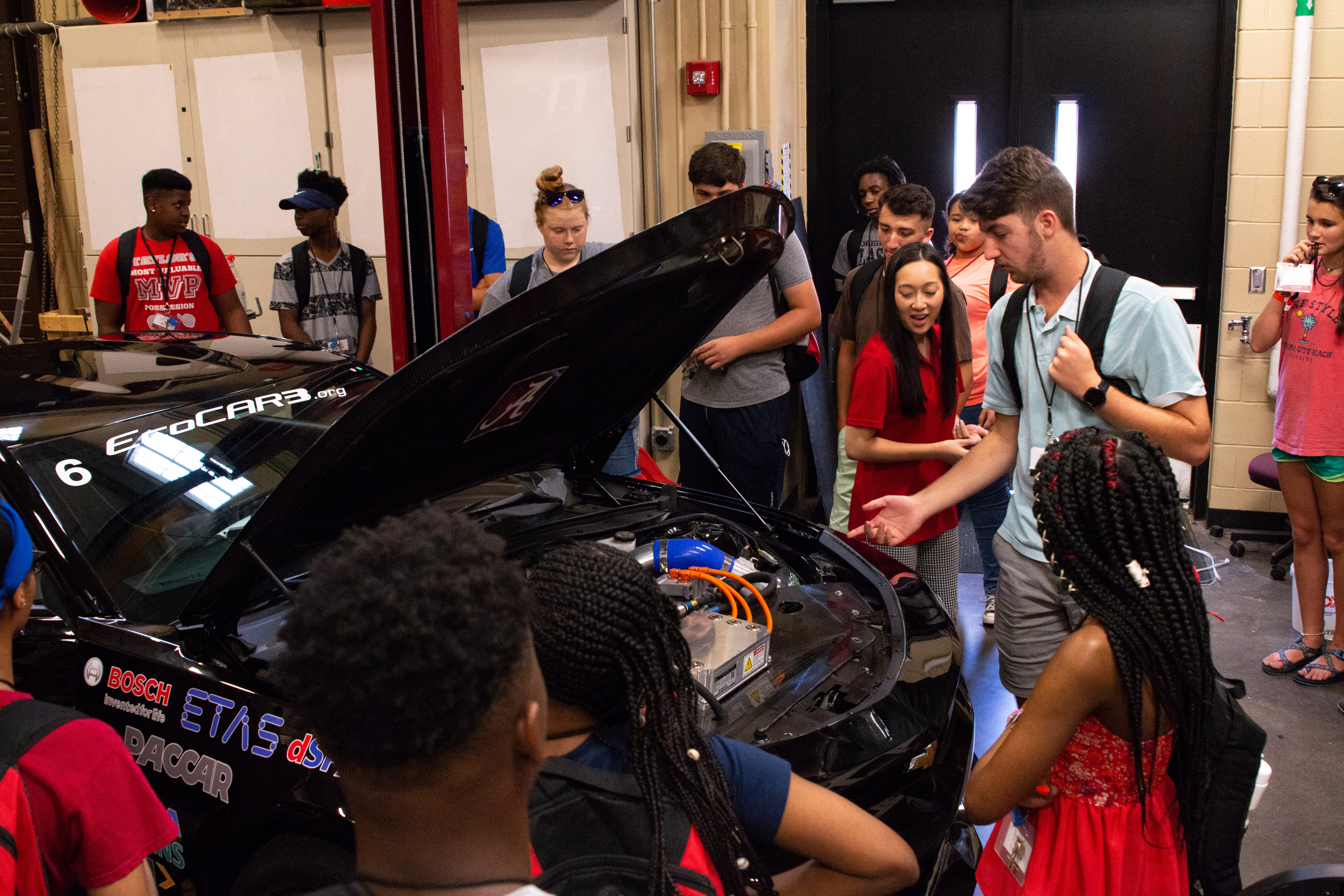 STEM Academy students experience a close encounter with EcoCAR3, guided by UA graduate student Ashley Phan.