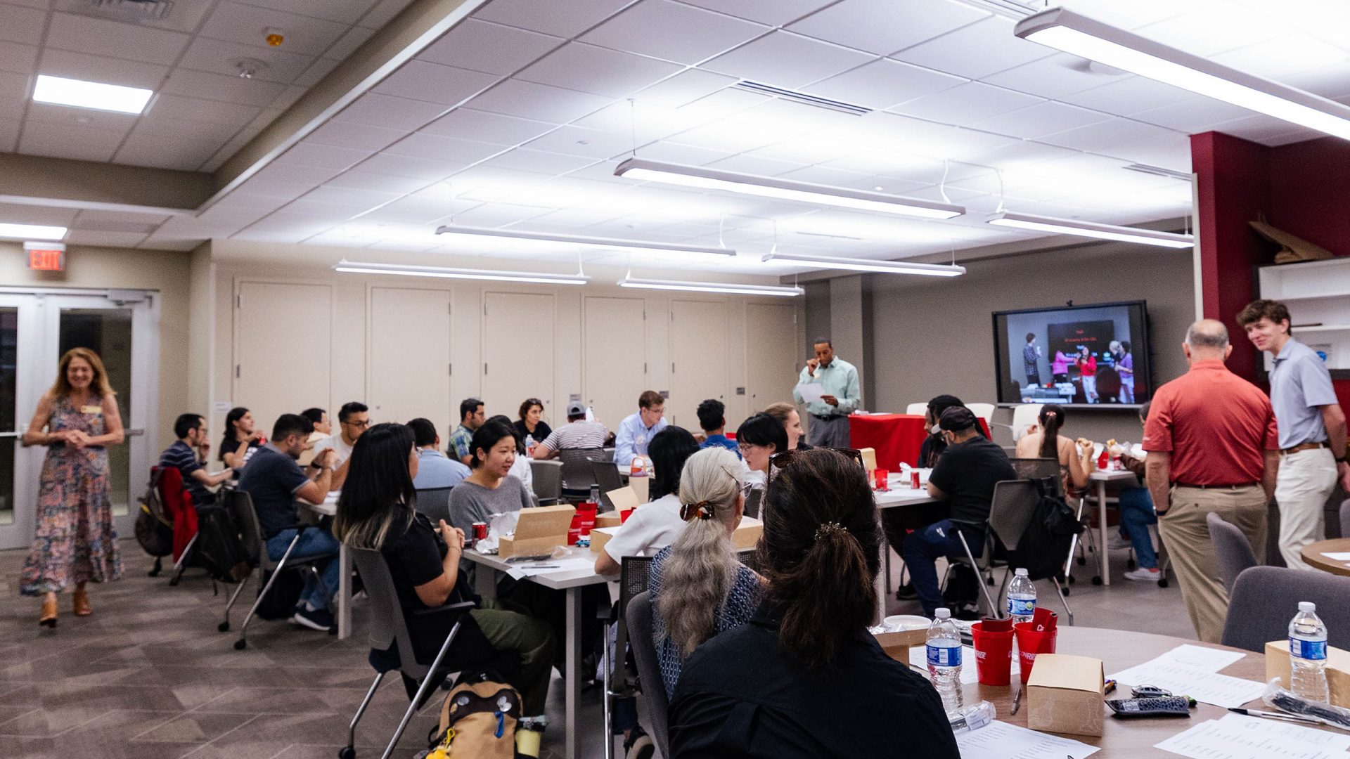 A group of students seated at tables in the Student Community Engagement Center